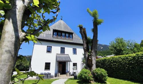 a white house with a gambrel roof at TURM KAPS Luxury home direkt am Golfplatz by Belle Stay in Kitzbühel