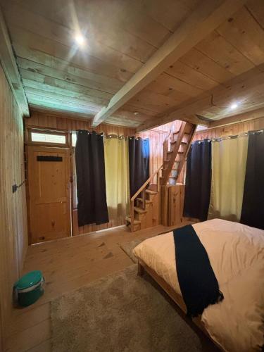 a bedroom with a bed in a wooden house at Kath Kuni Cafe & Stay Shangarh in Shangarh