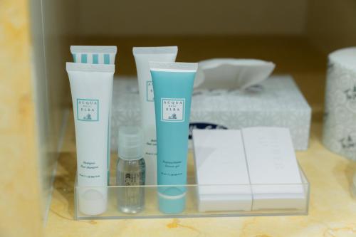 a glass shelf with four bottles of moisturizers on it at Hotel Florida Lerici in Lerici