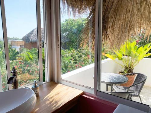 a bathroom with a large window with a tub and a table at Surfbreak B&B in Cabarete