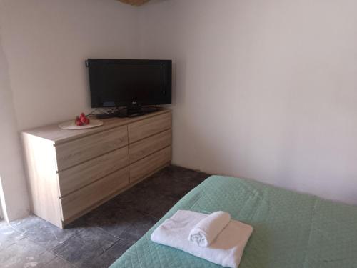 a bedroom with a bed and a flat screen tv at Casa vacanze CARTIA in Ragusa