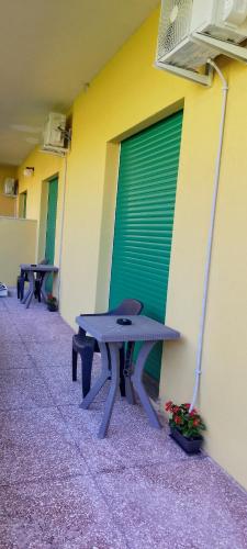 a picnic table next to a wall with a green door at Alloggio Turistico Casa Vela in Anzio