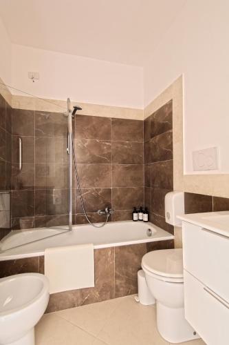 a bathroom with a tub and a toilet and a sink at Monolocale 19 in Rome