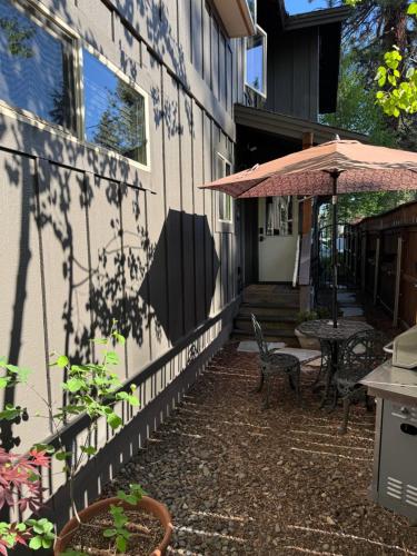 a patio with a table and an umbrella next to a building at Lake Tahoe Luxury Guest Quarters in South Lake Tahoe