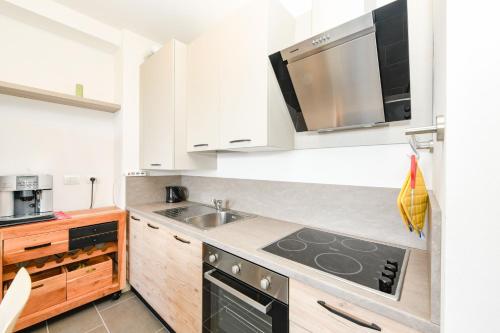 a kitchen with white cabinets and a stove top oven at Luna in Toscolano Maderno