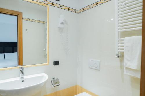 a white bathroom with a sink and a mirror at Hotel Florida Lerici in Lerici