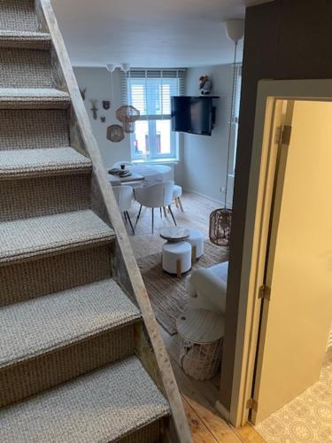 a staircase leading to a living room with a table at Au Coeur La Roche 2 in Mellet