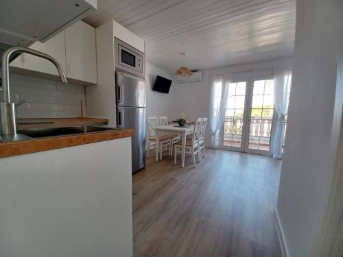 a kitchen and living room with a table and chairs at Fantástico apartamento "Sol y Sal" en Cala'n Bosch in Cala'n Bosch