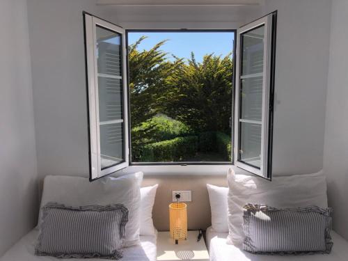 a bedroom with two pillows and a large window at Fantástico apartamento "Sol y Sal" en Cala'n Bosch in Cala'n Bosch