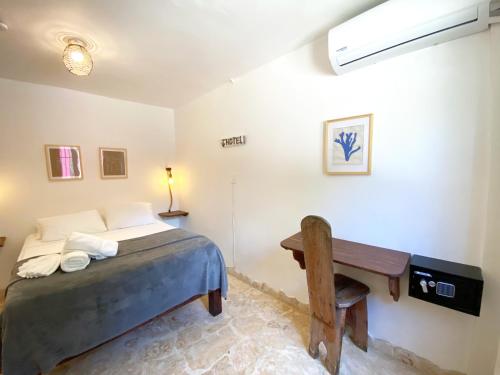 a bedroom with a bed and a desk in it at Surfbreak B&B in Cabarete
