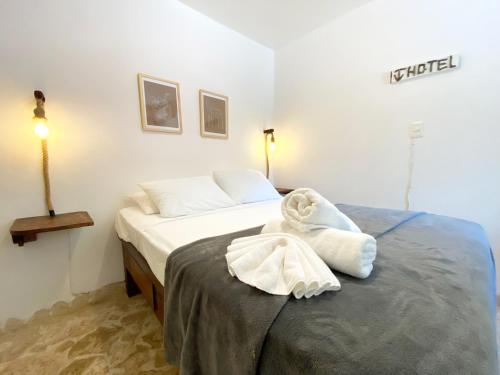 a bedroom with a bed with a towel on it at Surfbreak B&B in Cabarete