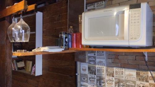a microwave sitting on top of a shelf at Cabana Hostel Guarulhos in Guarulhos