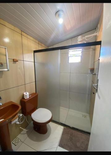 a bathroom with a shower and a toilet and a sink at Meu Cantinho na ilha in Fernando de Noronha