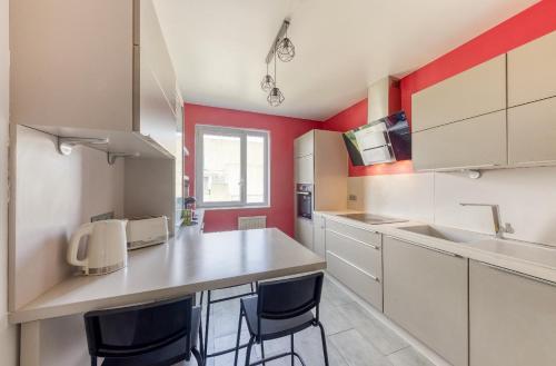 - une cuisine avec des placards blancs et des murs rouges dans l'établissement Chambre orange 4, Évry-Courcouronnes