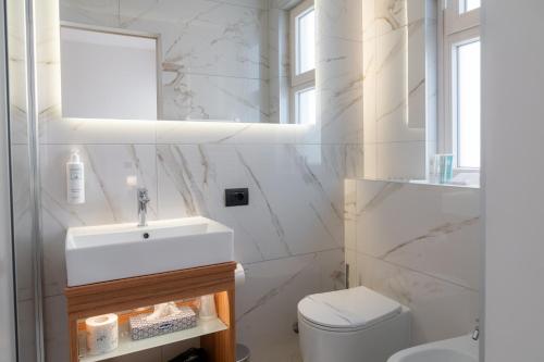 a white bathroom with a sink and a toilet at Hotel Florida Lerici in Lerici
