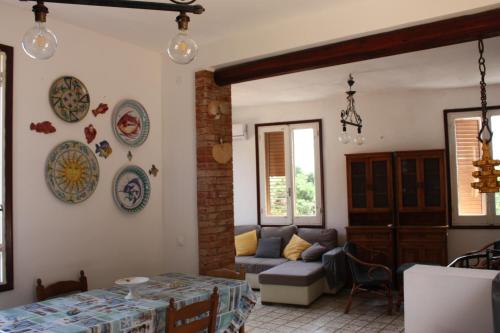 a living room with a couch and plates on the wall at Villa con Pineta tra paese e mare in Favignana