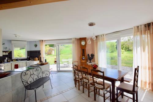 une cuisine et une salle à manger avec une table et des chaises dans l'établissement Le refuge du Chablais, à Saint-Paul-en-Chablais
