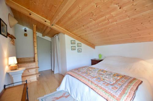 une chambre avec un lit et un plafond en bois dans l'établissement Le refuge du Chablais, à Saint-Paul-en-Chablais