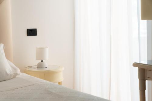 a bedroom with a bed and a lamp on a table at Hotel Florida Lerici in Lerici