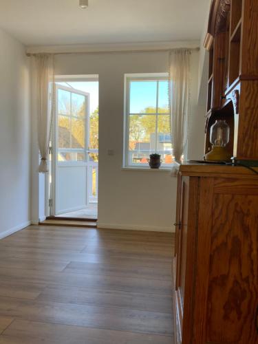 an empty living room with a door and windows at Stilvolles Naturidyll bei Berlin in Glienicke