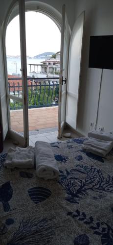 a bedroom with two beds and an open door with a balcony at Alloggio panoramico sul mare di Vindicio in Formia