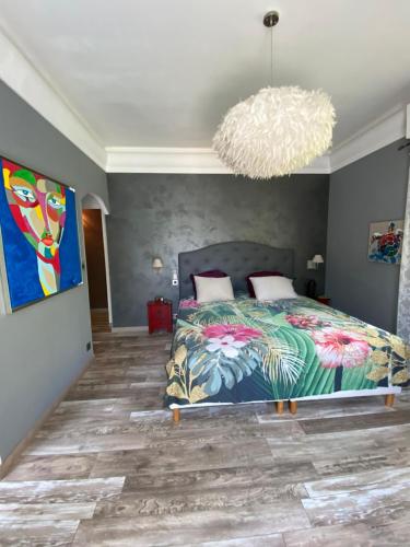 une chambre avec un lit et un lustre dans l'établissement Villa Amnesia Cap dAntibes with Pool and luxurious Garden, à Antibes