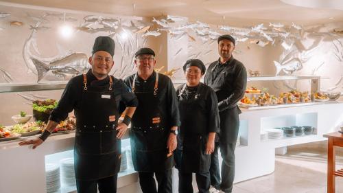 un grupo de chefs parados frente a un mostrador en Essence Hotel Boutique, en Torremolinos