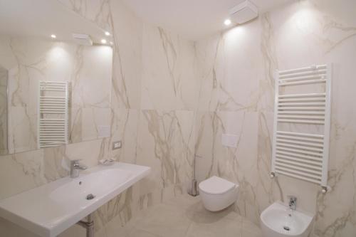 a white bathroom with a sink and a toilet at Hotel Residence Imperial in Misano Adriatico