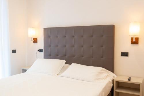 a bed with a large headboard in a bedroom at Hotel Florida Lerici in Lerici