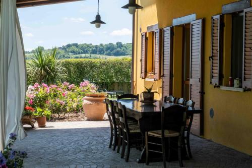 a table and chairs on a patio with flowers at B&B La Casa del Gallese in Sorbolongo