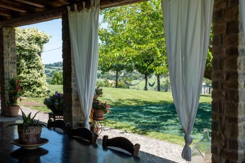 an open porch with curtains and a view of a yard at B&B La Casa del Gallese in Sorbolongo