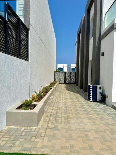 a walkway next to a white building at Ocean Breeze ALMARSA 3BR VILLA for Family and Friends in Fujairah