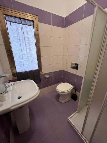 a bathroom with a toilet and a sink at B&B Andromeda in Palmi