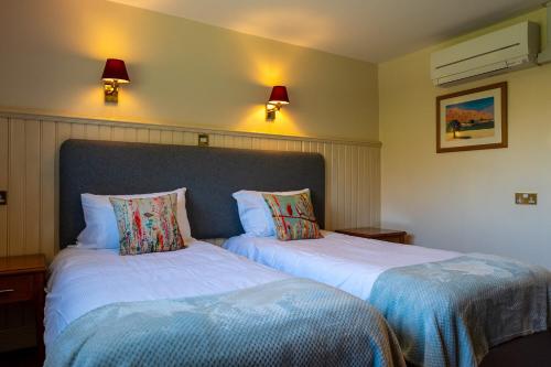 two beds sitting next to each other in a room at The Evenhill in Canterbury
