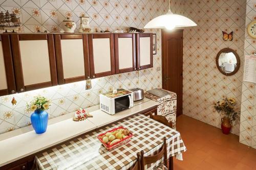 a kitchen with a table with a microwave and a bowl of fruit at CristallPont Amalfi Day in Atrani