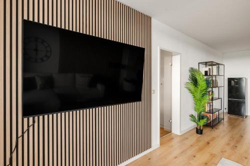 a living room with a large television on a wall at Beyond Living Horizon in Gelsenkirchen