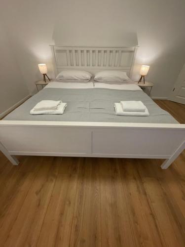 a white bed with two towels on top of it at Stilvolles Naturidyll bei Berlin in Glienicke