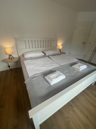 a large white bed with two towels on it at Stilvolles Naturidyll bei Berlin in Glienicke