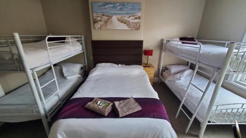 a room with two bunk beds and a bed at Leecliff Guest House in Blackpool