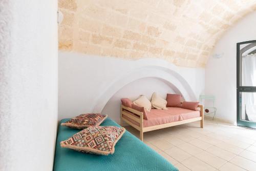 a living room with a couch and pillows on the floor at La Casa delle Rondini by BarbarHouse in Monacizzo