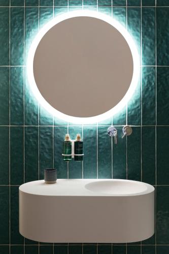 a bathroom with a round mirror and a sink at Quinta da Torre - Anselmo Mendes in Cortinhas