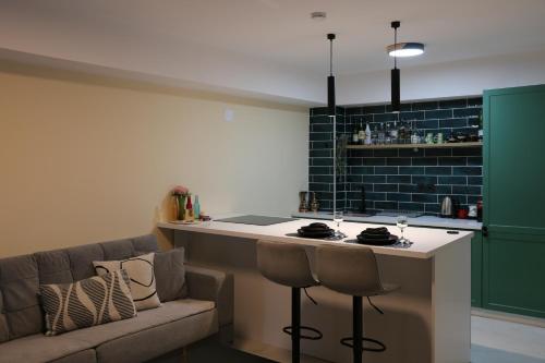 eine Küche mit einem Sofa und einer Bar mit einer Theke in der Unterkunft Bazar Charm- Cozy Urban Retreat in Skopje Historic Heart in Skopje