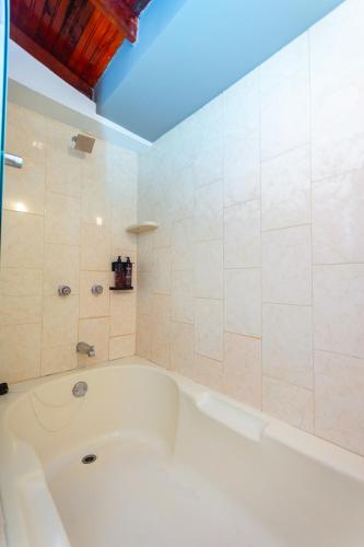 a white bath tub in a bathroom with a ceiling at Mandala Medellin Botero By GyC Hotels in Medellín