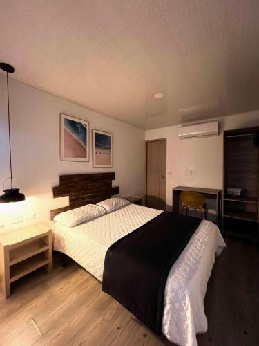 a bedroom with a large bed and a desk at Hotel Room 2 in Cali