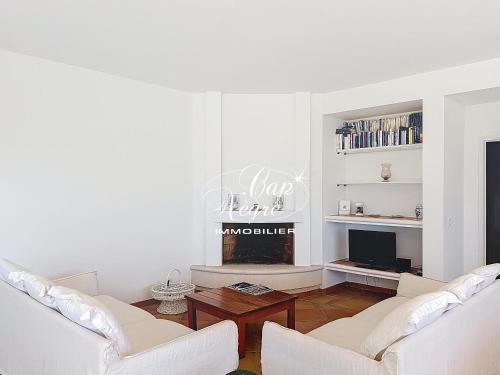 a living room with two white couches and a fireplace at maison pour 9 personnes vue mer a 150 m de la plage du rayol in Rayol-Canadel-sur-Mer