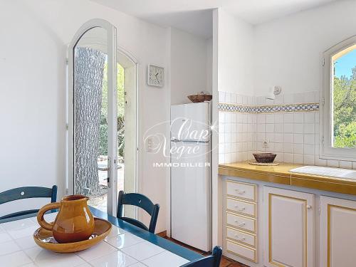 a kitchen with a table and chairs and a refrigerator at maison pour 9 personnes vue mer a 150 m de la plage du rayol in Rayol-Canadel-sur-Mer