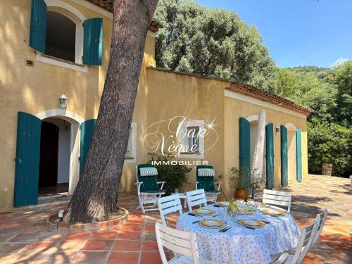 a table and chairs in front of a building at maison pour 9 personnes vue mer a 150 m de la plage du rayol in Rayol-Canadel-sur-Mer
