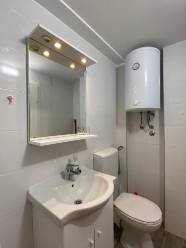 a white bathroom with a sink and a toilet at Rose Garden in Mokošica
