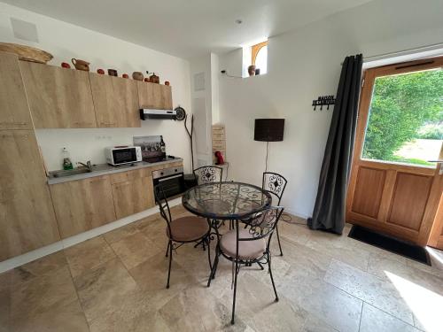 une salle à manger avec une table et des chaises en verre dans l'établissement L'Echo de la nature, à Sasseville