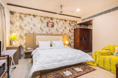 sypialnia z dużym białym łóżkiem i kanapą w obiekcie Penthouse with Jacuzzi steam bath &foot massage w mieście Gurgaon